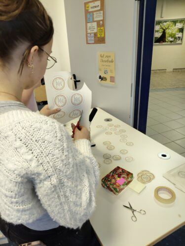 Eine Schülerin schneidet für eine Aktion zum Thema Demokratie Sticker aus