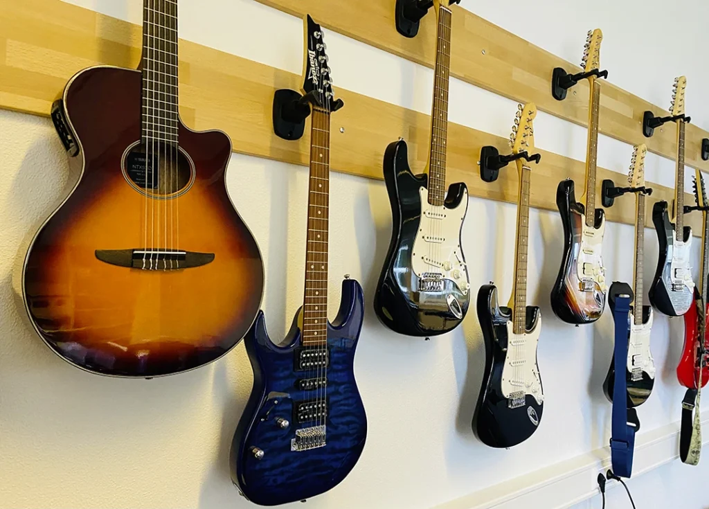 verschiedene Arten von Gitarren hängen an der Wand